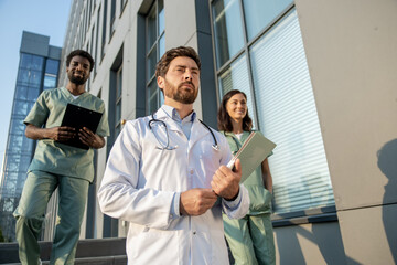 Doctors in lab coats near the hospital looking determined and looking confident