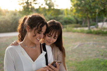 Two women in a loving couple sharing a tender moment at the park