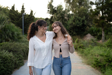 Fototapeta premium Two girls in a loving couple sharing a tender moment at the park