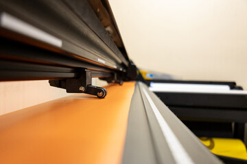 Cutting plotter close-up. The process of cutting a vinyl film. Cutting plotter makes adhesive...