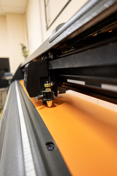 Cutting plotter close-up. The process of cutting a vinyl film. Cutting plotter makes adhesive lettering from vinyl foil