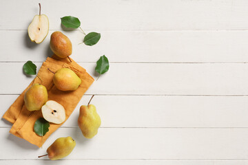 Sweet ripe pears and leaves on white wooden background