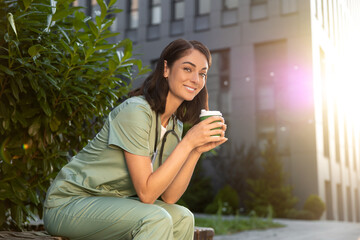 Young female doctor having coffee in the morning after a night shift