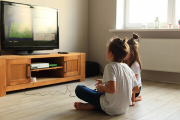 A lively scene of a boy and girl enthusiastically playing video games together at home. they...