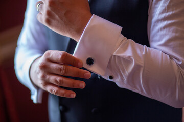 Groom Adjusting Cufflinks on White Shirt Before Wedding