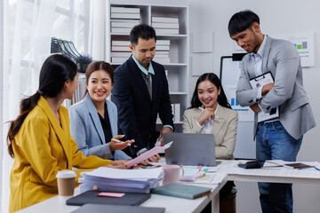 Group of confident business asian people point to graphs and charts to analyze market data, balance sheet, account, net profit to plan new sales strategies to increase production capacity.	