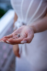 Gentle Close-up of Woman Holding a Stylish Silver Ring in Hand - Elegant Jewelry and Hand Photography for Fashion and Accessories