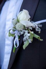 White rose boutonniere on a black tuxedo