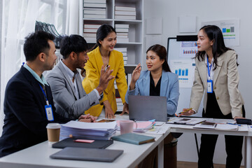 Group of confident business asian people point to graphs and charts to analyze market data, balance sheet, account, net profit to plan new sales strategies to increase production capacity.	