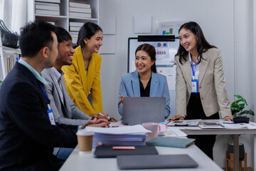 Group of confident business asian people point to graphs and charts to analyze market data, balance sheet, account, net profit to plan new sales strategies to increase production capacity.	