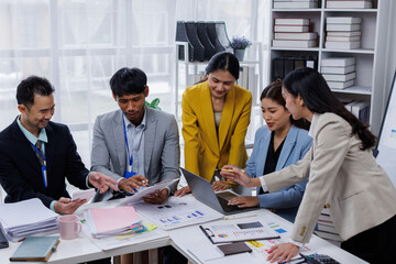 Group of confident business asian people point to graphs and charts to analyze market data, balance sheet, account, net profit to plan new sales strategies to increase production capacity.	