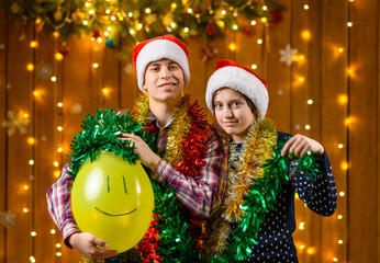 A teenage boy and a girl pose with in the New Year decorations with festive illumination and garlands, Christmas lights and decorations, festive theme