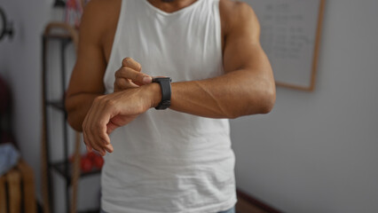 Man wearing smart watch inside gym checking time during workout in the gymnasium