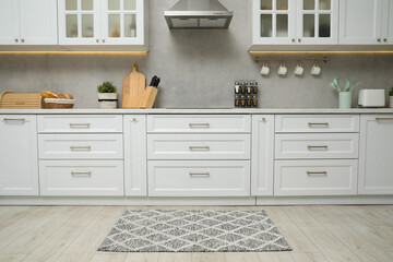 Beautiful rug on wooden floor in kitchen