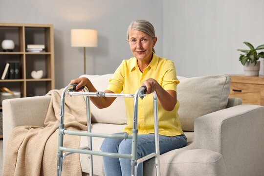 Senior woman with walking frame on sofa at home