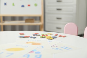 Learning alphabet. Different magnetic letters and pictures on white table indoors