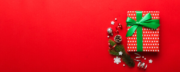Obraz premium Top view Flat lay Christmas decorations and gift box on colored background with copy space. Christmas or Happy New Year composition