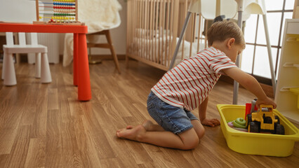 Toddler boy playing with toys on the floor of a kindergarten room, showcasing a happy childhood in an indoor, home-like setting.