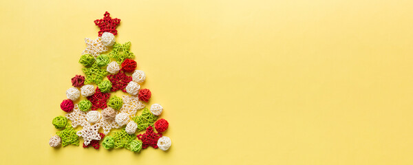 Christmas tree made from colored handmade ball decoration on colored background, view from above. New Year minimal concept with copy space