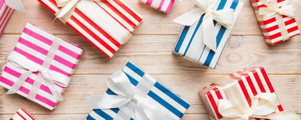 Fototapeta premium A lot of Christmas gift boxes in colored paper decorated on table, Top view close up. Many present New Year gift