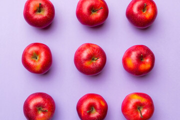 Many red apples on colored background, top view. Autumn pattern with fresh apple above view
