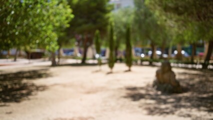 Fototapeta premium Blurred outdoor park with defocused trees, bench, and sunlight casting shadows creating a serene atmosphere