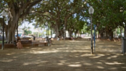 Blurred outdoor scene with a woman and man in a defocused park setting featuring trees, streetlights, and benches under bokeh lighting