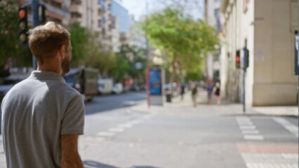 Man walking along a blurred city street with buildings and people defocused in the background on a sunny day