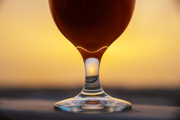 Silhouette of Glass of Beer Against a Golden Sunset