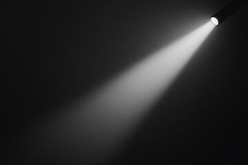 A beam of light cuts through darkness, showcasing the contrast of illumination against a black background.