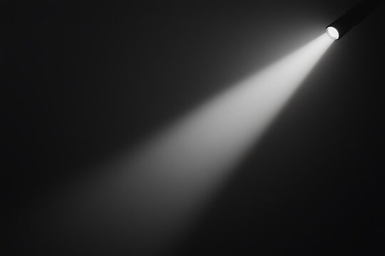 A beam of light cuts through darkness, showcasing the contrast of illumination against a black background.