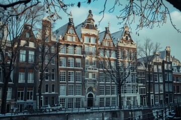 Canal in amsterdam lined with traditional dutch houses covered in snow during winter