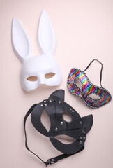 Different carnival masks on a beige background