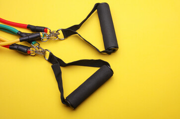 Rubber expander with handles for fitness on a yellow background