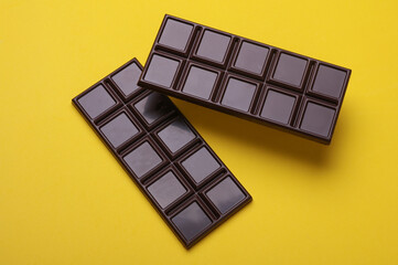 Dark chocolate bars on a yellow background