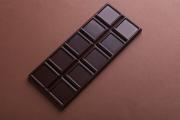 Dark chocolate bar on a brown background