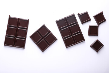 Blocks of broken chocolate bar on white background