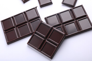 Blocks of broken chocolate bar on white background