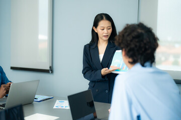 Businesswoman presents an environmental sustainability report to colleagues in a meeting, discussing eco-friendly strategies and green initiatives in a professional setting.