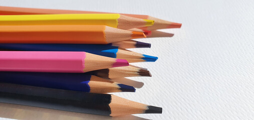 Fototapeta premium A set of colored pencils isolated on white background. Drawing pencils. A set of colored pencils for school. Bright palette of colors. Pencils in a pencil case.