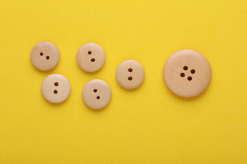 Wooden buttons on a yellow background
