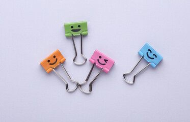 Binder clips with a smiling face on gray background. Business concept. Creative layout