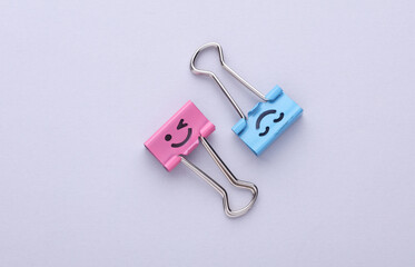 Binder clips with a smiling face on gray background. Business concept. Creative layout