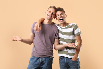 Portrait of happy brothers on beige background