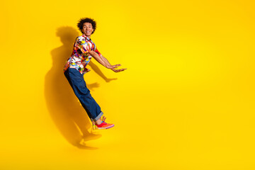 Obraz premium Full size photo of nice funky young man jump fall empty space wear shirt isolated on bright yellow color background