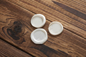 Mockup of white wax seals on wooden background