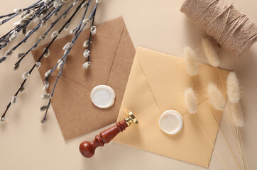 Envelopes with wax seals and vintage stamp, willow branches, lagurus flowers on beige background....