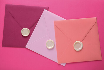 Colored Envelopes with wax seals on pink background. Gift certificate, wedding invitation