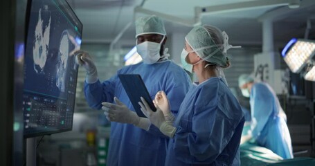 Black Male and Caucasian Female Surgeons Analyze Brain Scans on a Digital Monitor, Planning Surgical Strategy in a High-tech Operating Room. Colleagues Working Together, Preparing for Surgery - Powered by Adobe