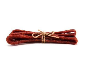 Kabanos thin dry sausage. Pile of mini smoked dry-cured sausages tied with vintage rope isolated on...